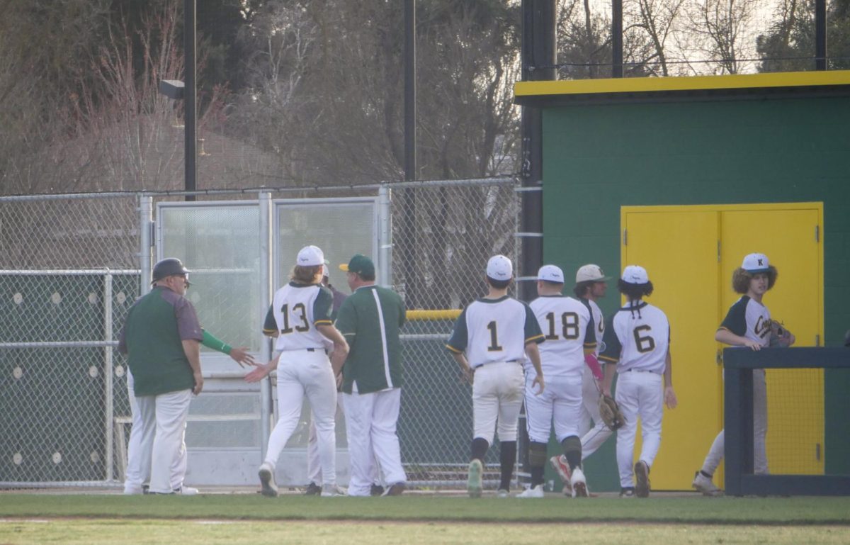 JFK baseball players walk back to the dugout after the first inning on Feb 20. The score around the first inning was 2-0 with Burbank in the lead.
