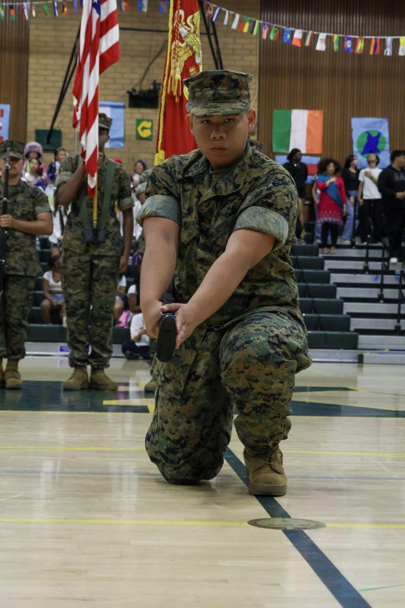 MCJROTC Cadet Cpl. Lerch Austero posing during the national anthem at the Multicultural rally on Friday March 20 at the Kennedy gym. This was a tradition at the start of the rally, where the Star Spangled Banner is played.