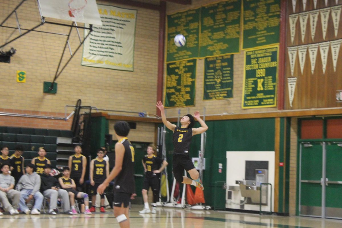 Senior Troy Vue (#2) leaps into the air to serve the ball during the match on Thursday March 5. His serve helped Kennedy start the rally and put immediate pressure on Florin. 