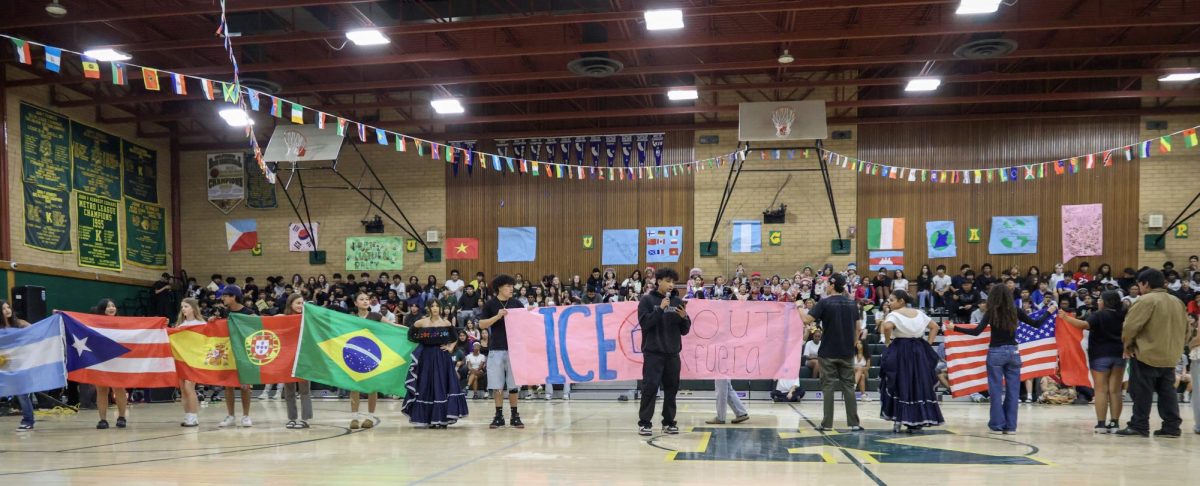 Brown Issues Club speaks about ICE in America standing with South America countries flags. On Friday March 20 at the Kennedy Gym after the dancers performances