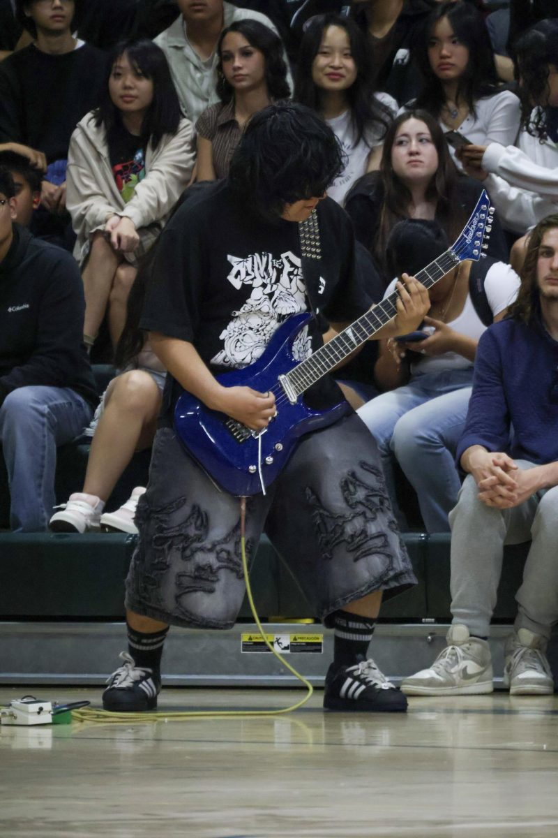 Guitarist Daniel Zarate playing his guitar at the Multicultural rally on Friday March 20, at the Kennedy gym. His performance was for the metal band, Eschaton.